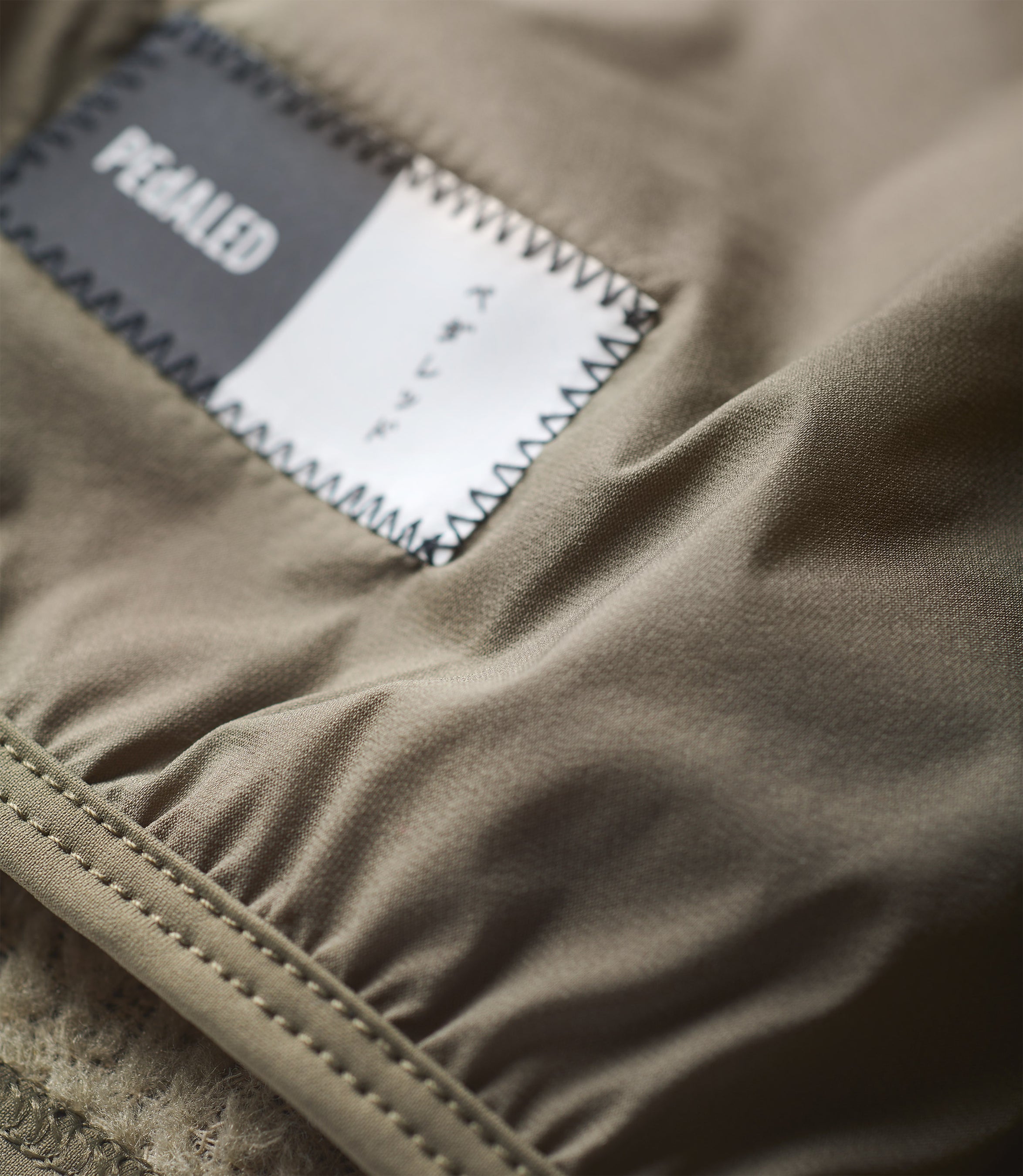 24WANEL11PE_3_cycling neck warmer polartec alpha green element detail pedaled