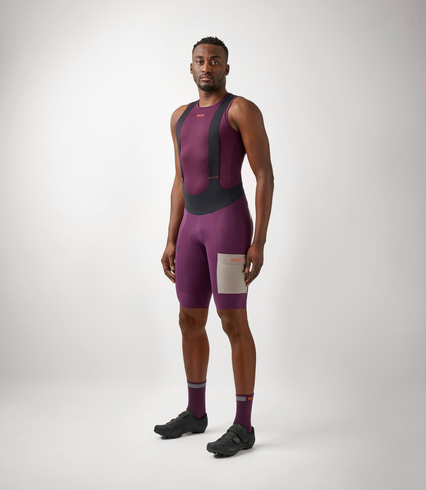 23SBBOD10PE_3_men cycling cargo bibshort purple odyssey total body front pedaled