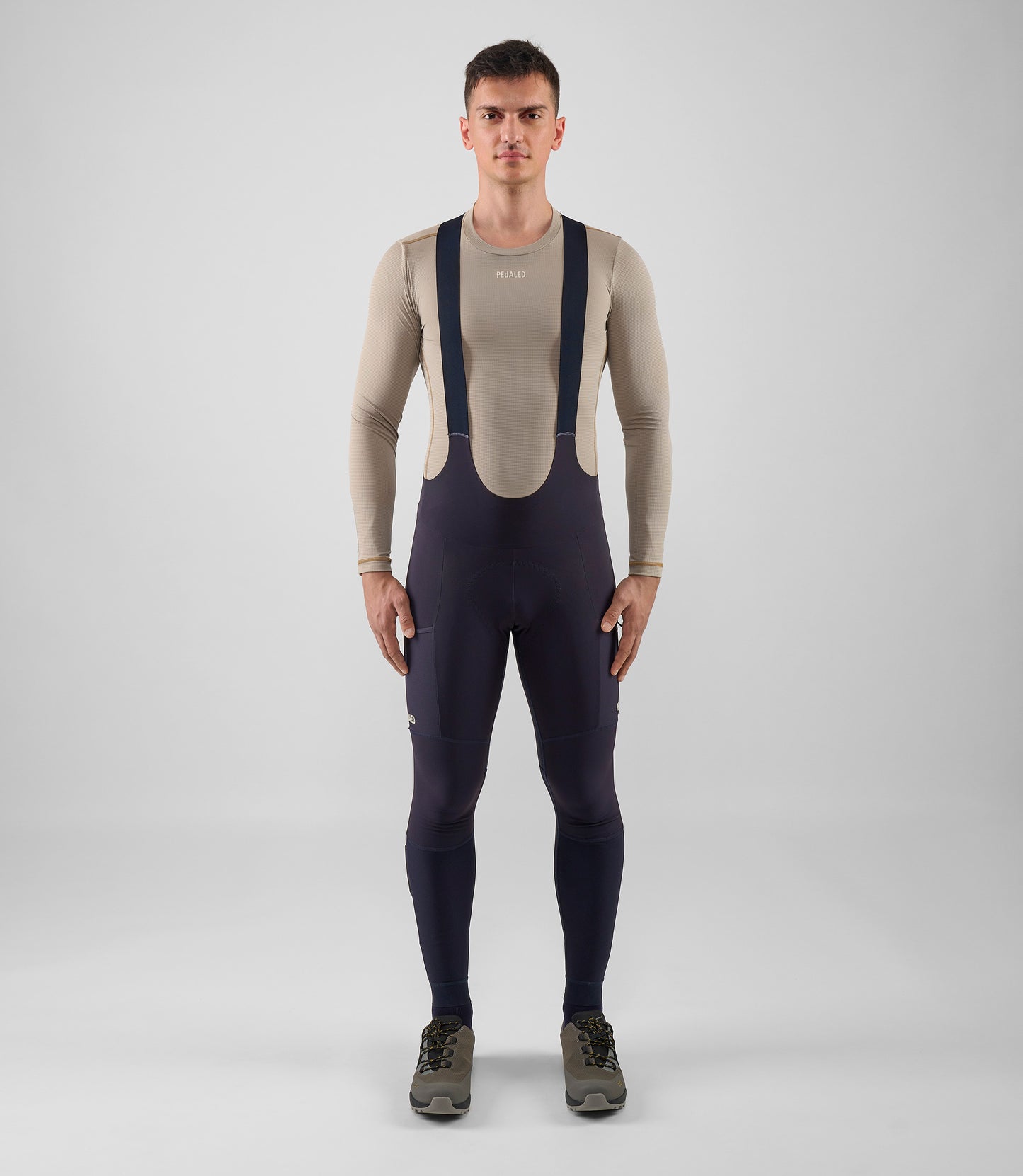 25WWTOD74PE_2_men cycling cargo bib tight dark navy odyssey total body front pedaled
