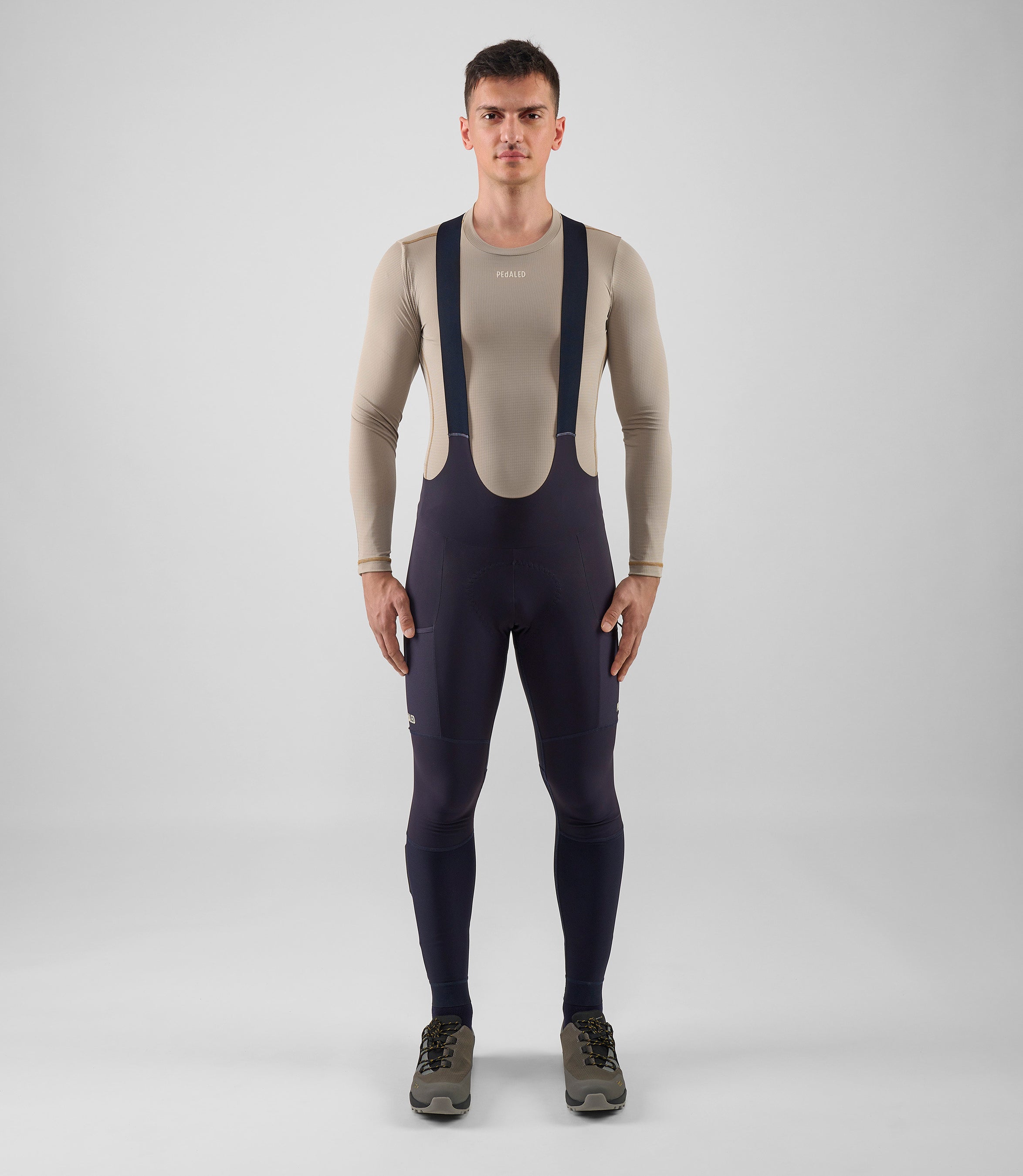 25WWTOD74PE_2_men cycling cargo bib tight dark navy odyssey total body front pedaled