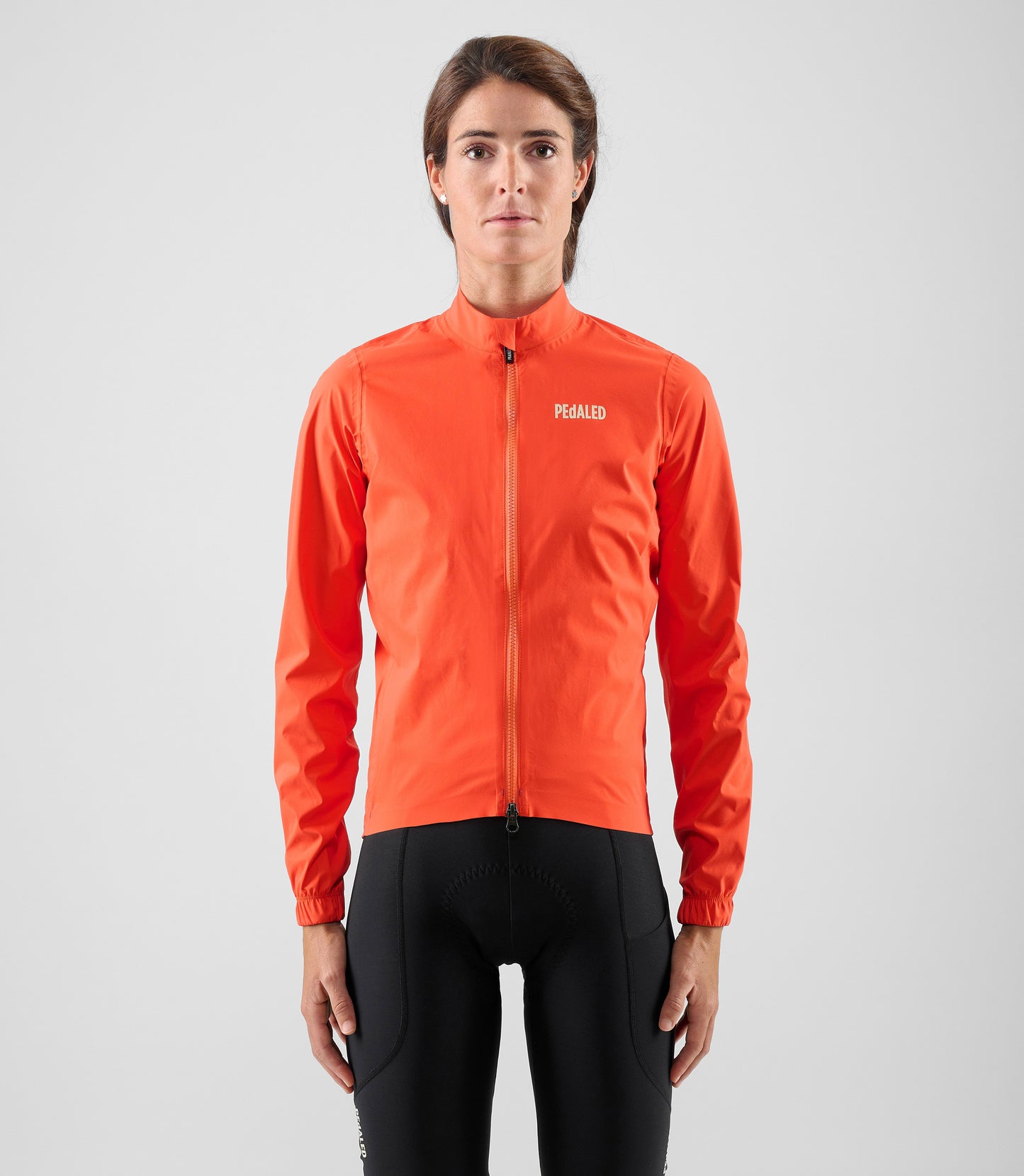 W5WWJEL12PE_3_women cycling waterproof jacket orange element total body front pedaled