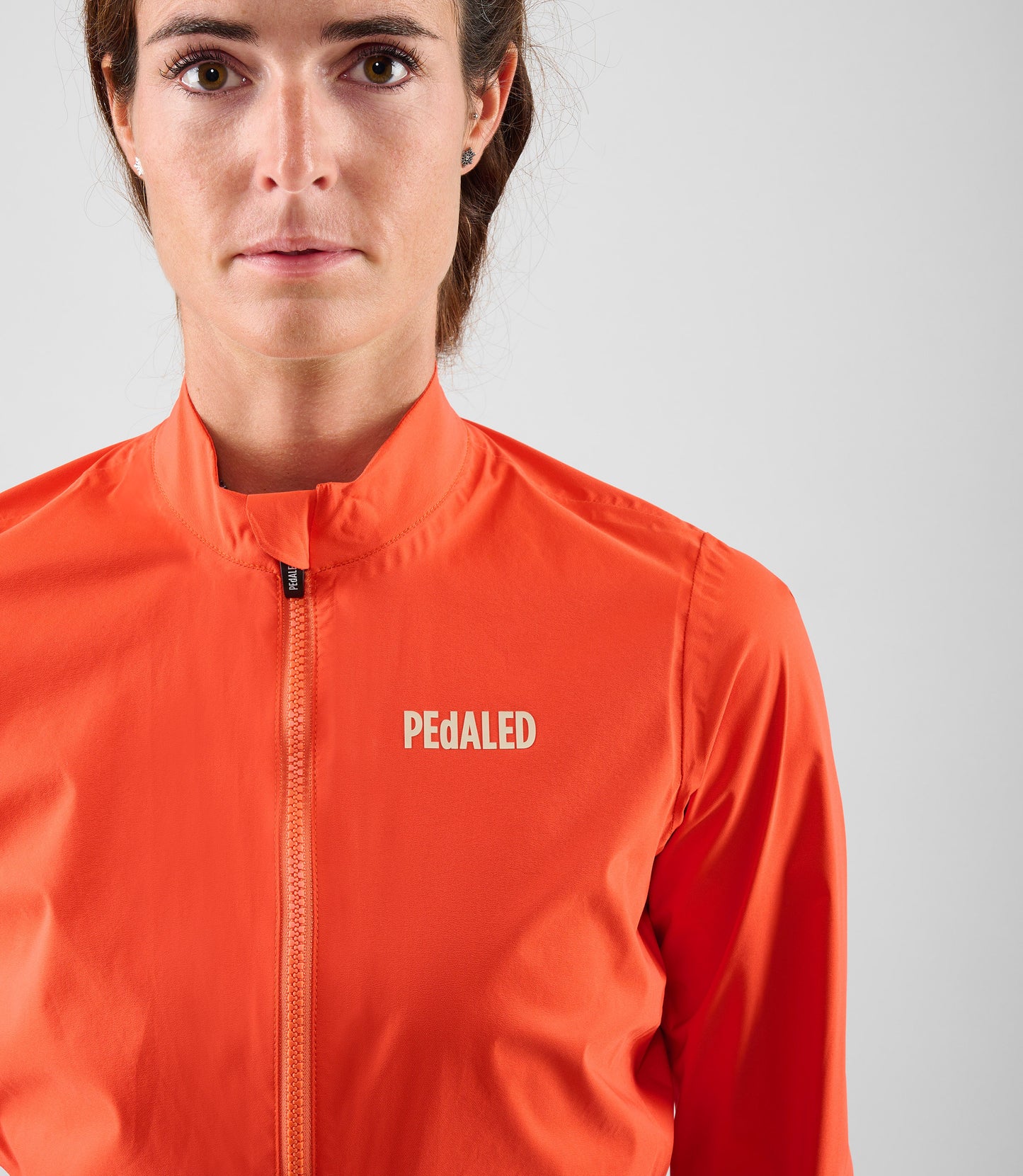 W5WWJEL12PE_5_women cycling waterproof jacket orange element front pedaled